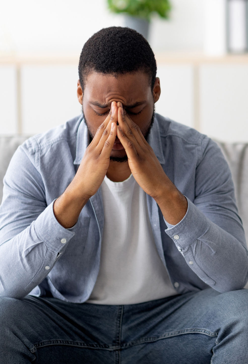 Desperate black man suffering from nevrous breakdown or depression, having session at psychologist's office, panorama